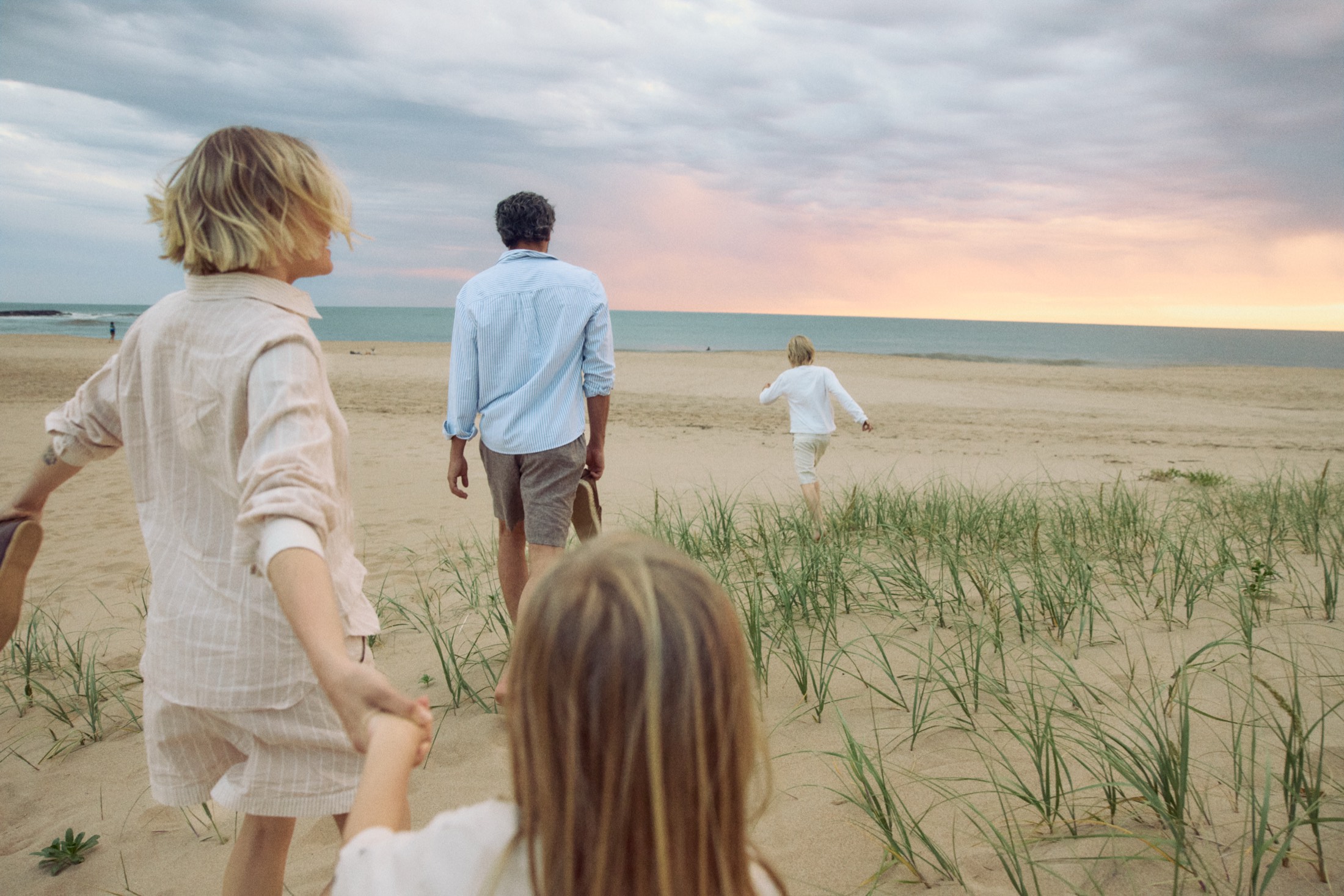 Una familia caminando por la playa al atardecer