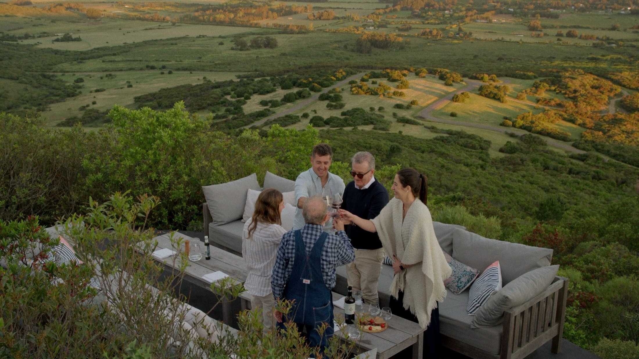 Un brindis en la ladera, con el paisaje de Agreste de fondo